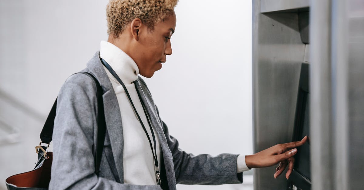 Where to find arrival/departure locations of Greyhound buses during online purchase? - Young African American woman touching screen of ticket machine in metro station