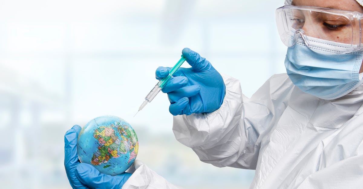 where to get an on-arrival COVID-19 PCR test in Jordan? - Doctor hand wearing glove injecting syringe of Coronavirus vaccine concept, syringe of vaccine and needle planting on the planet earth , Coronavirus COVID-19	