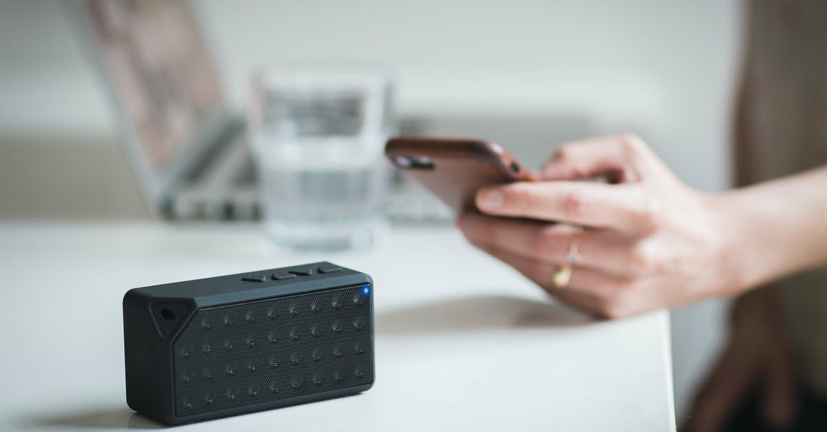 Where to get free WiFi access at JFK, landside and airside? - Person Holding Iphone Beside Black Portable Speaker