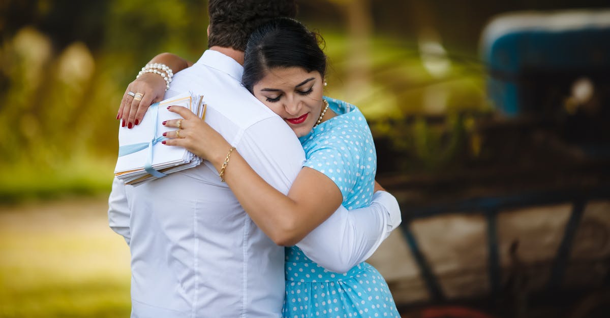 Where to meet outside Heathrow T3? - Ethnic couple in summer clothes hugging in green garden