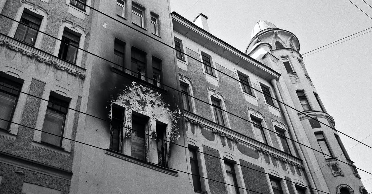 Where to print out flight info on a public holiday in Mexico City when your accommodation won't do it? - Black and white of exterior of aged residential building with dirty windows and walls after fire placed in city in daytime