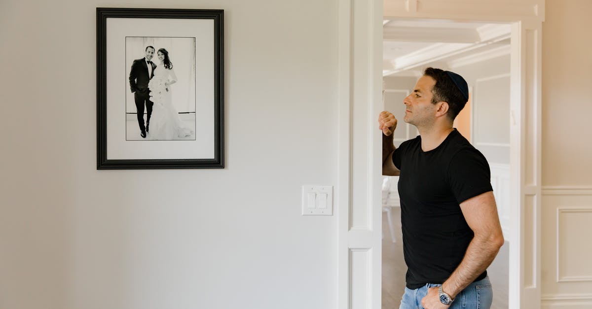 Where was this photograph taken? - A Man Looking at a Picture Frame on the Wall