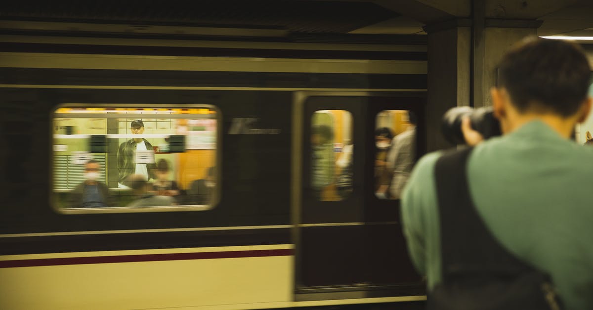 Where was this train photograph taken? - Photographer with modern device taking photo of train with passengers