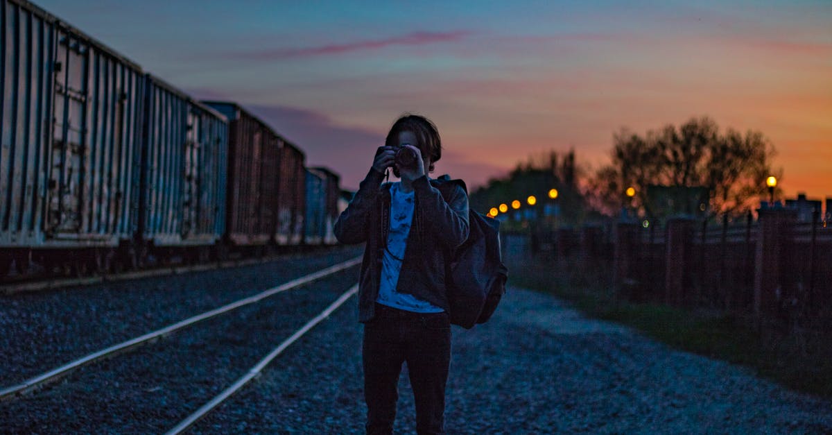 Where was this train photograph taken? - Man Wearing Brown Jacket With Backpack Taking Photo during Golden Hour