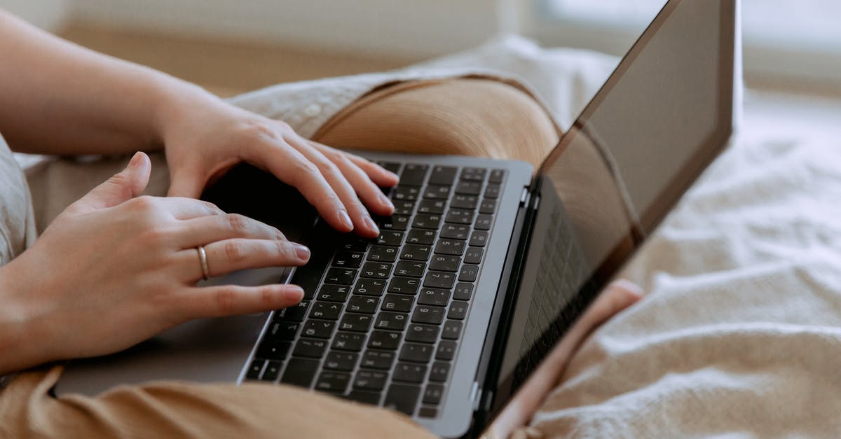 Which airlines ban the use of Knee Defenders during flight? - Faceless woman using laptop while sitting on bed