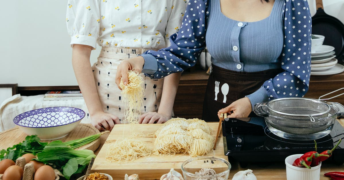 Which airlines provide on-board WiFi in Chinese airspace? - Crop anonymous ladies in aprons standing near wooden table with various ingredients and utensil while preparing to cook homemade pasta together