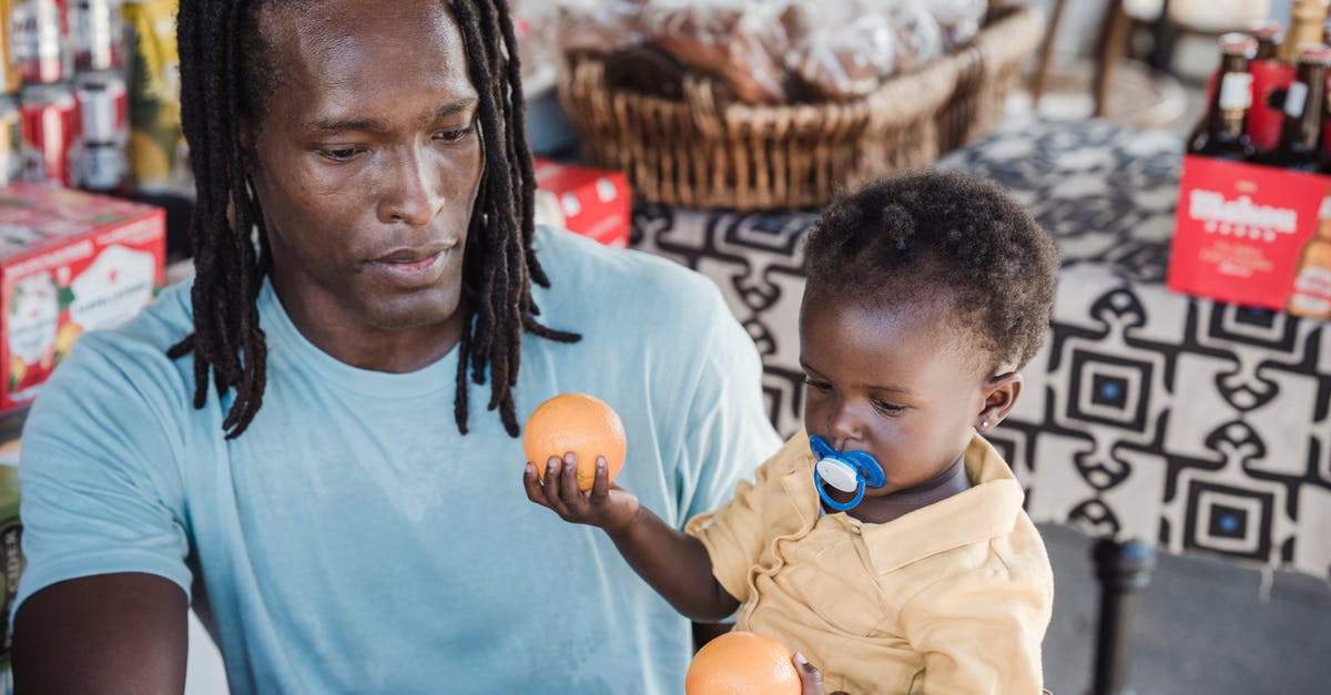 Which are cheapest Thailand Supermarket Chains? - Man and a Child Holding Fresh Oranges