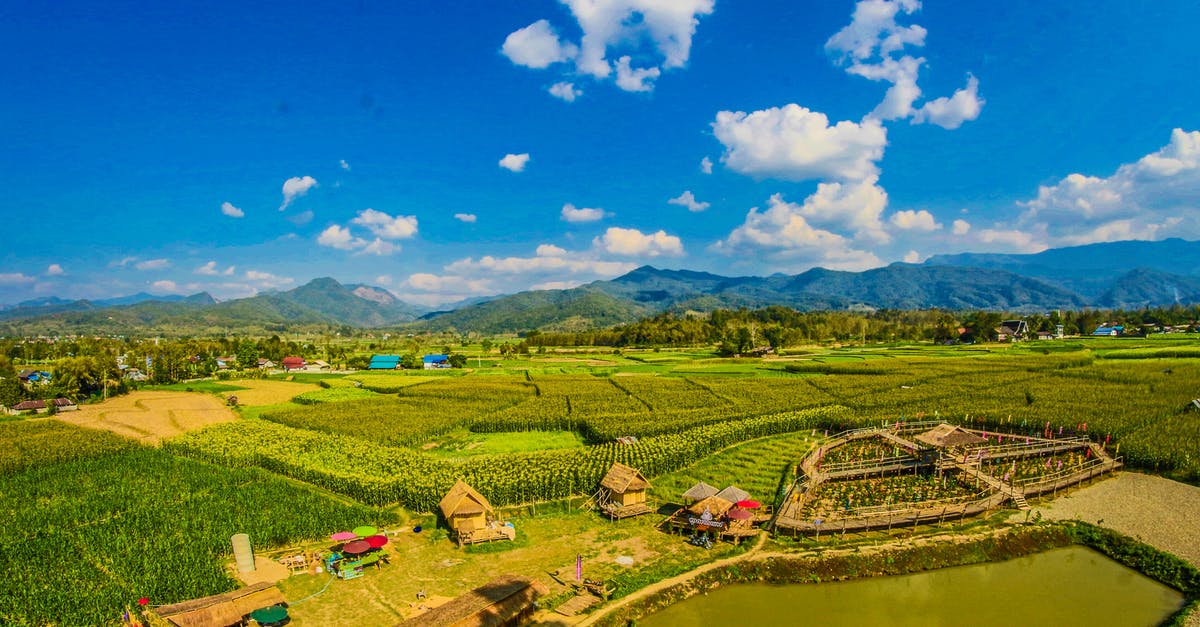 Which countries in Southeast Asia require travel insurance proof? - Rice Field With Mountain and Houses during Cloudy Day