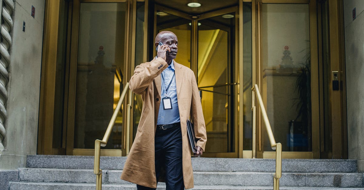 Which entrance to use for the Louvre? - Pensive black man talking on phone walking down stairs