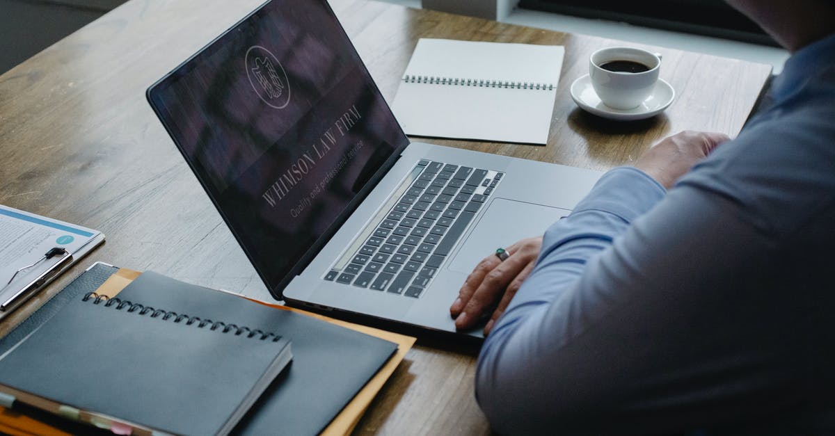 Which ferry company offers online check-in from Tallin to Stockholm? - From above of crop anonymous businessman using netbook while sitting at table with documents and cup of hot coffee