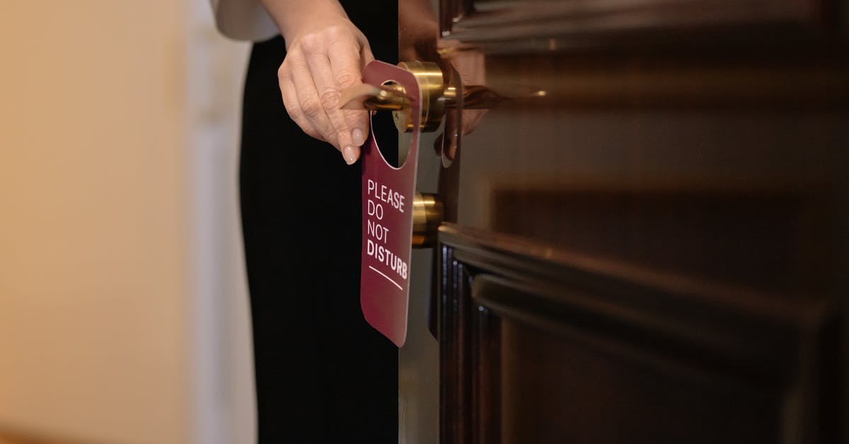 Which hotel reward program should I sign up for? [closed] - Woman Putting a Sign on the Door of a Hotel Room