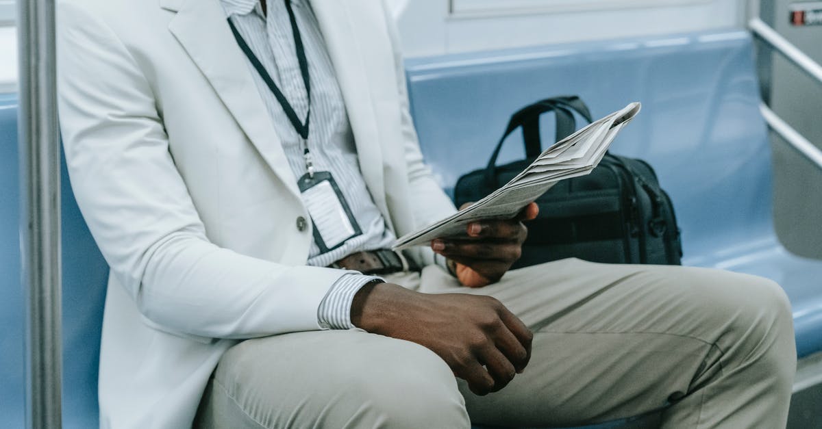 Which is the largest train in terms of passengers? - Man in White Suit Jacket and Gray Pants Sitting on Blue Couch