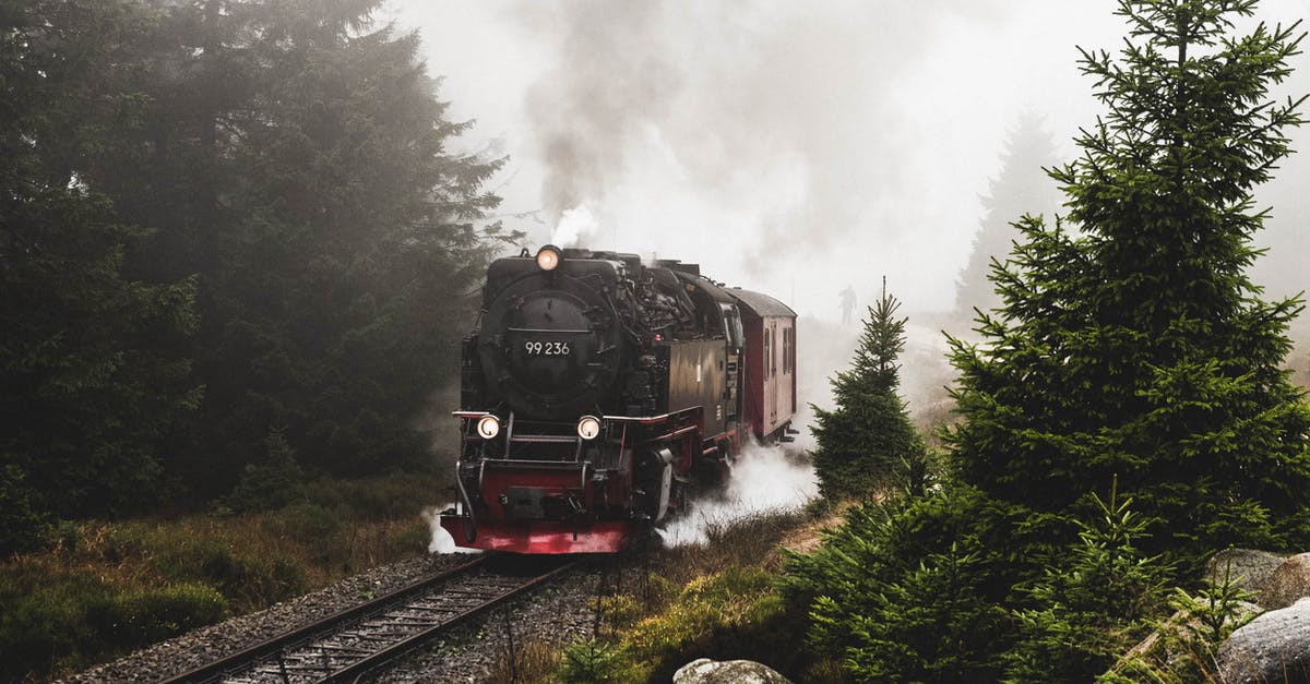 Which is the longest route/train travel possible? - Red and Black Train on Rail Tracks Near Green Trees