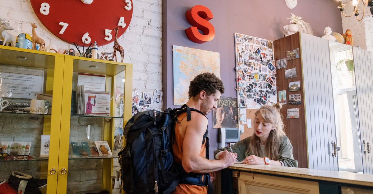 Which kind of accommodation allows guests to stay overnight? - Tourist Standing in front of Reception Desk 