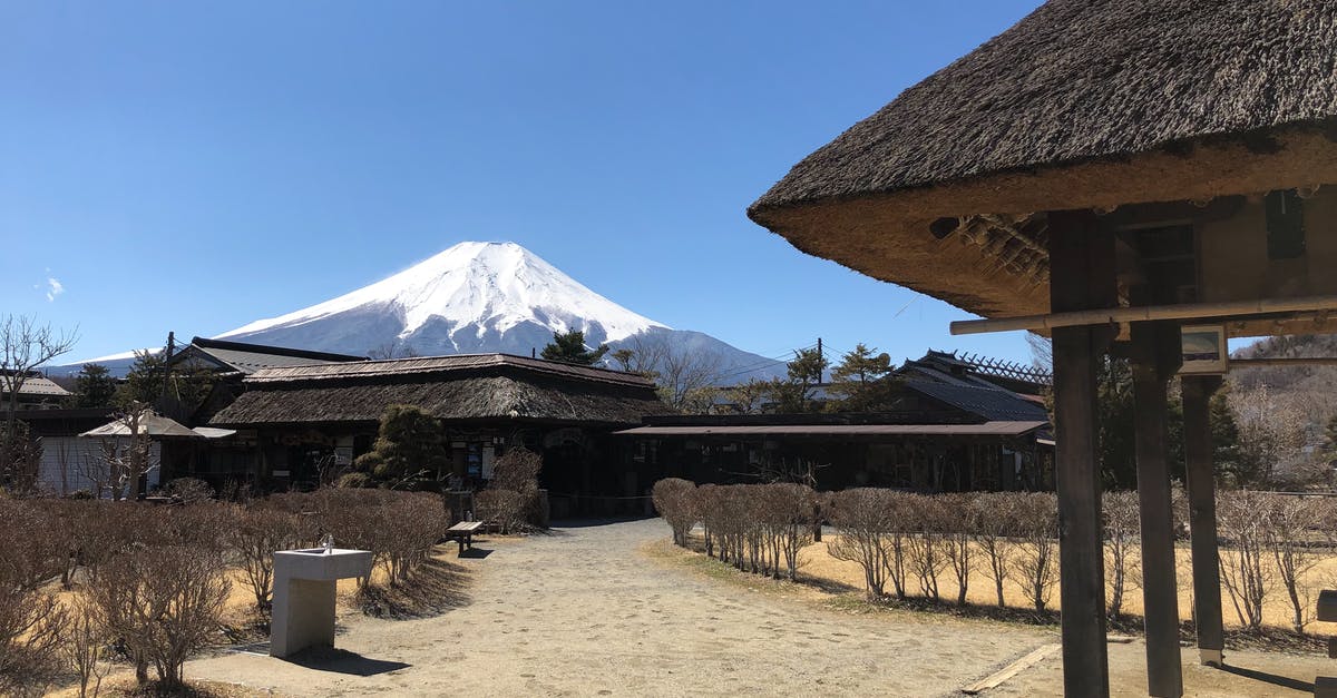 Which months in Japan lowers probability of natural disaster? - Brown Wooden House Near Mountain Under Blue Sky