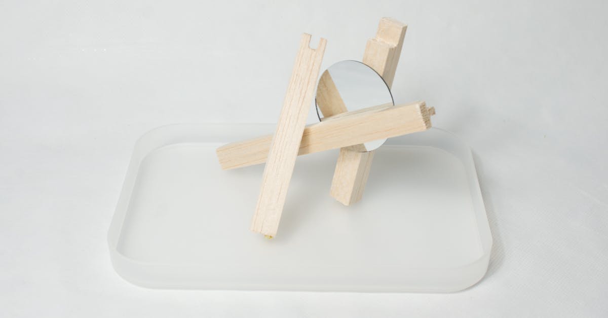 Which Nazca line figure is this? - High angle of wooden sticks with mirror placed on glass stand against white background