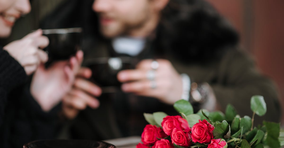 Which Onsen Ryokan do Tim Ferris and Kevin Rose speak about? - Crop couple with coffee interacting at cafe table with flowers