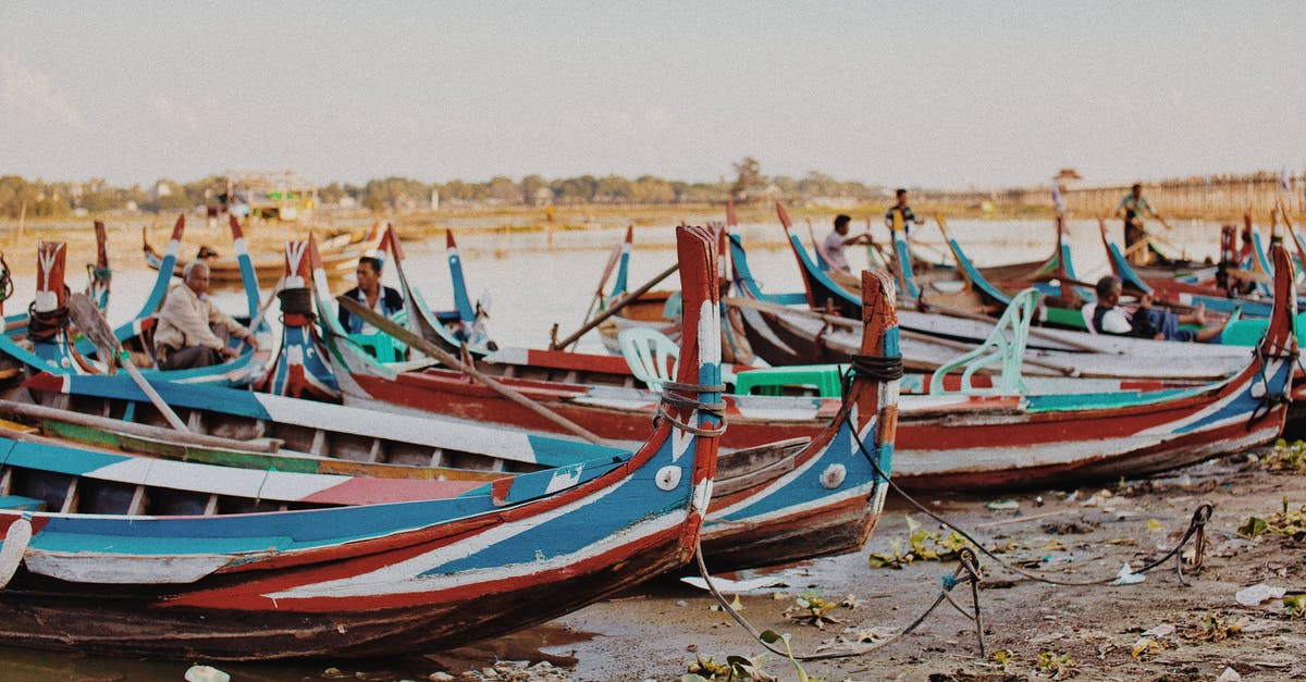 Which Thai provinces don't allow inter-provincial travel? - Colorful wooden fishing boats on sandy seashore