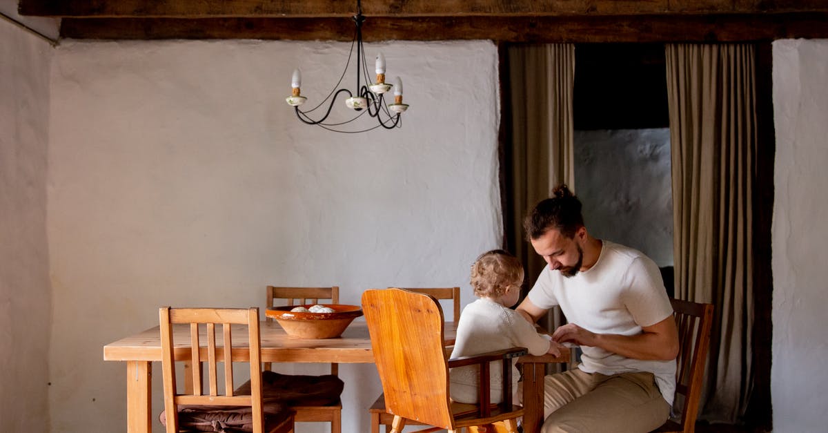 White House tours on weekends? - Focused young man with toddler girl sitting at desk in rural interior house