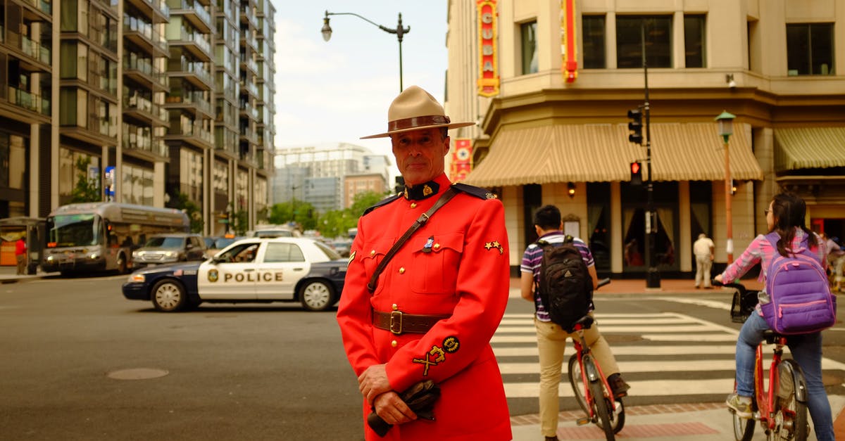 Who goes first? Person disembarking bus or the bicycle? - Man in Uniform Standing on Sidewalk