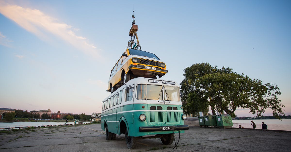 Who goes first? Person disembarking bus or the bicycle? - Teal Bus With Yellow Car on Roof