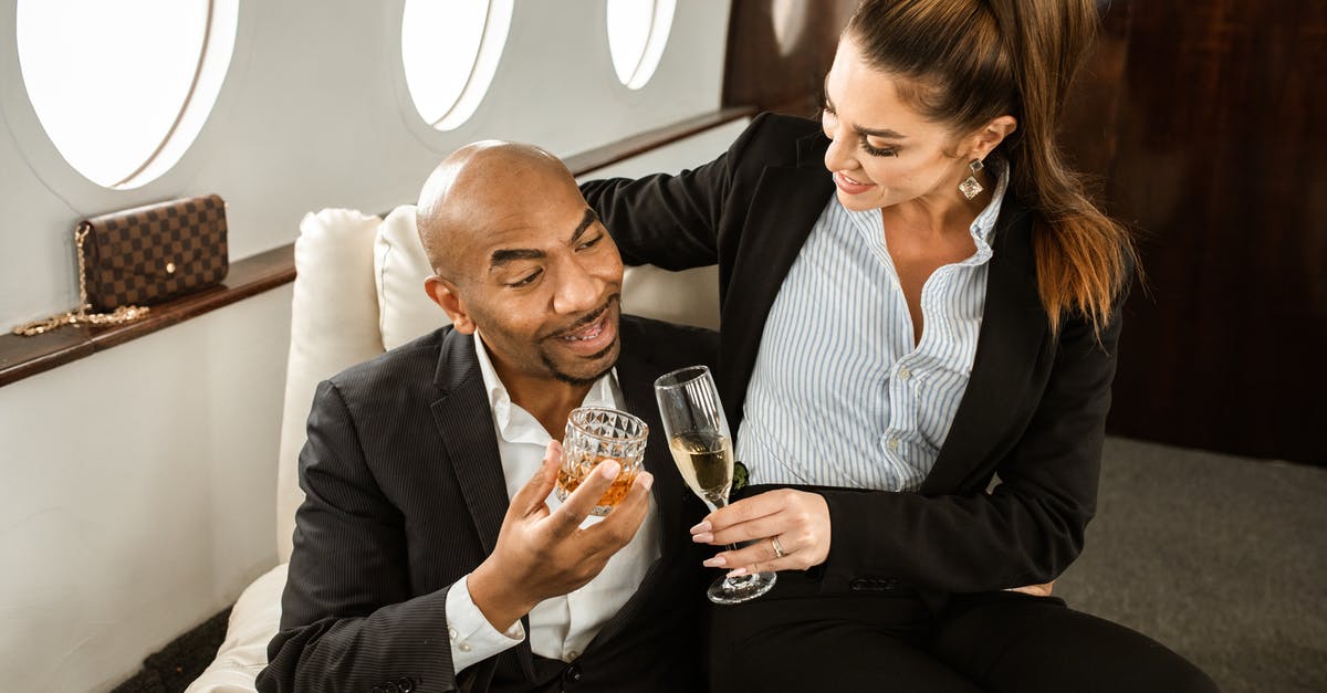 Who is checking and what about passengers heading to Canada? - Man in Black Suit Jacket Sitting Beside Woman in Black Blazer