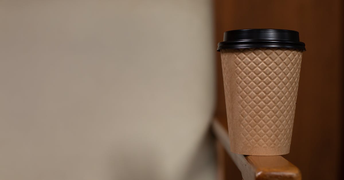 Who owns the middle armrest in airplanes? [closed] - Disposable Cup on the Armrest of a Chair