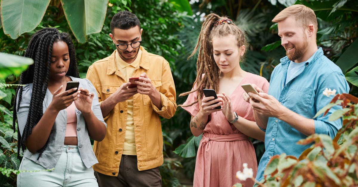 Why are mobile phones prohibited at many consulates? - Photo Of People Holding Cellphones