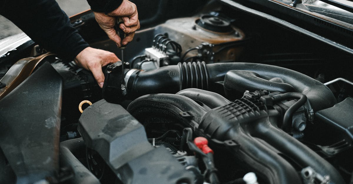 Why are there additional fees for checking in? [closed] - An Auto Mechanic Checking the Engine of a Car