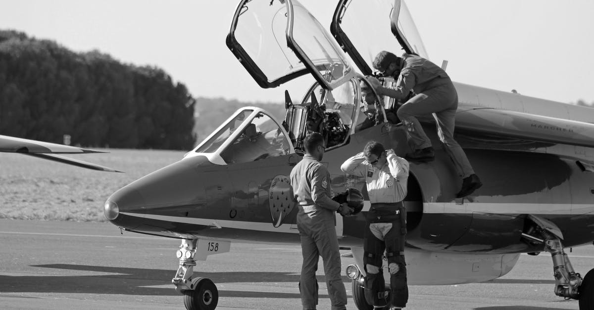 Why are there ashtrays on airplanes? [duplicate] - Grayscale Photo of Man in Black Jacket and Pants Walking on Black and White Helicopter