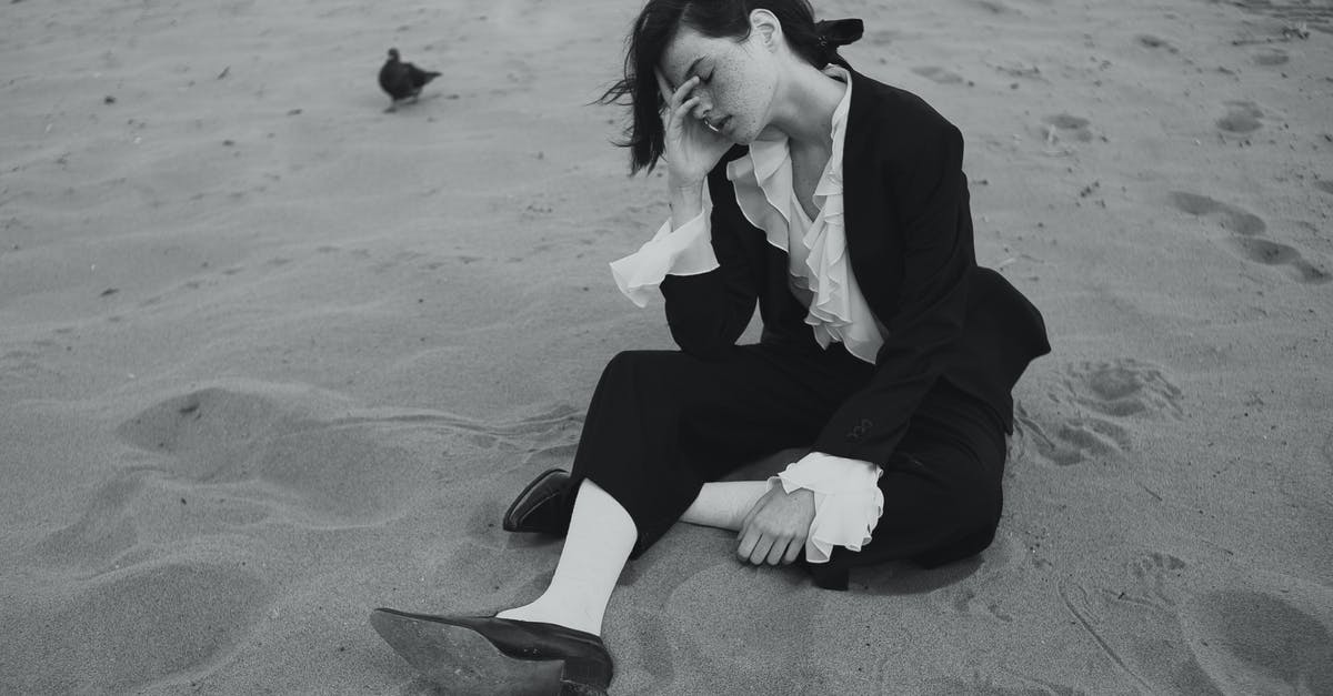 Why black sand beaches have black sand? [closed] - Young Brunette Woman in Formal Outfit Sitting on Sand