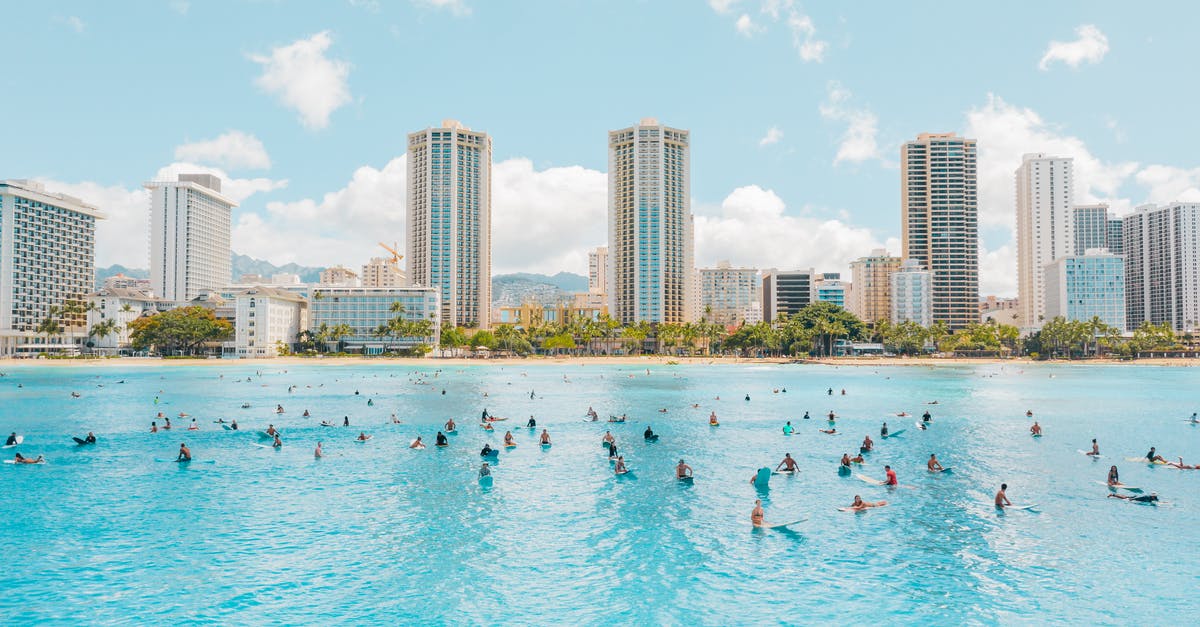 Why do hotels often not allow you to swim after dark? - People Swimming on Beach Near High Rise Buildings