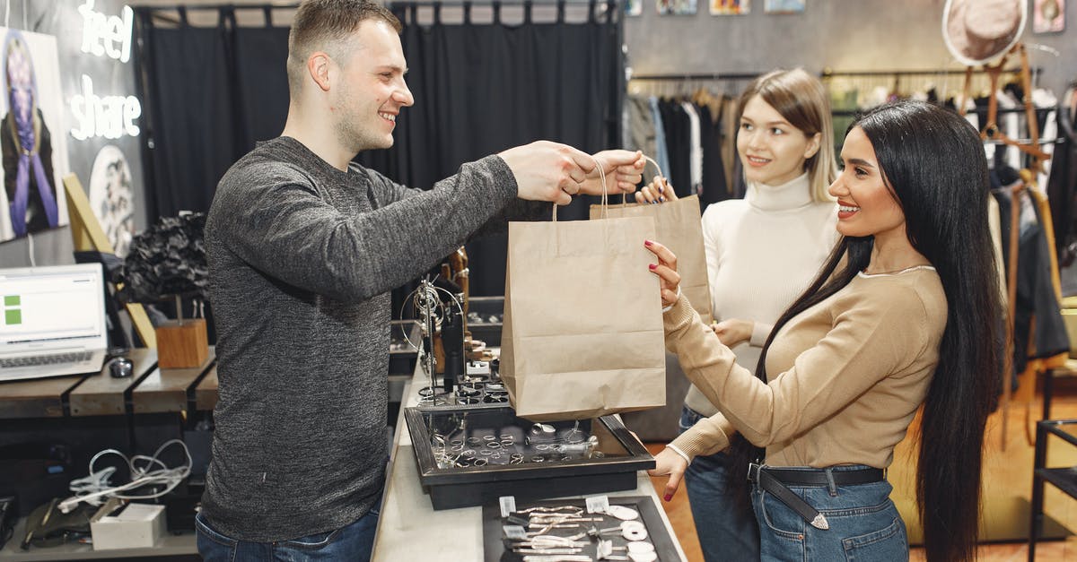 Why do many airports offer bag wrapping services? - Female customers getting paper bags at counter desk