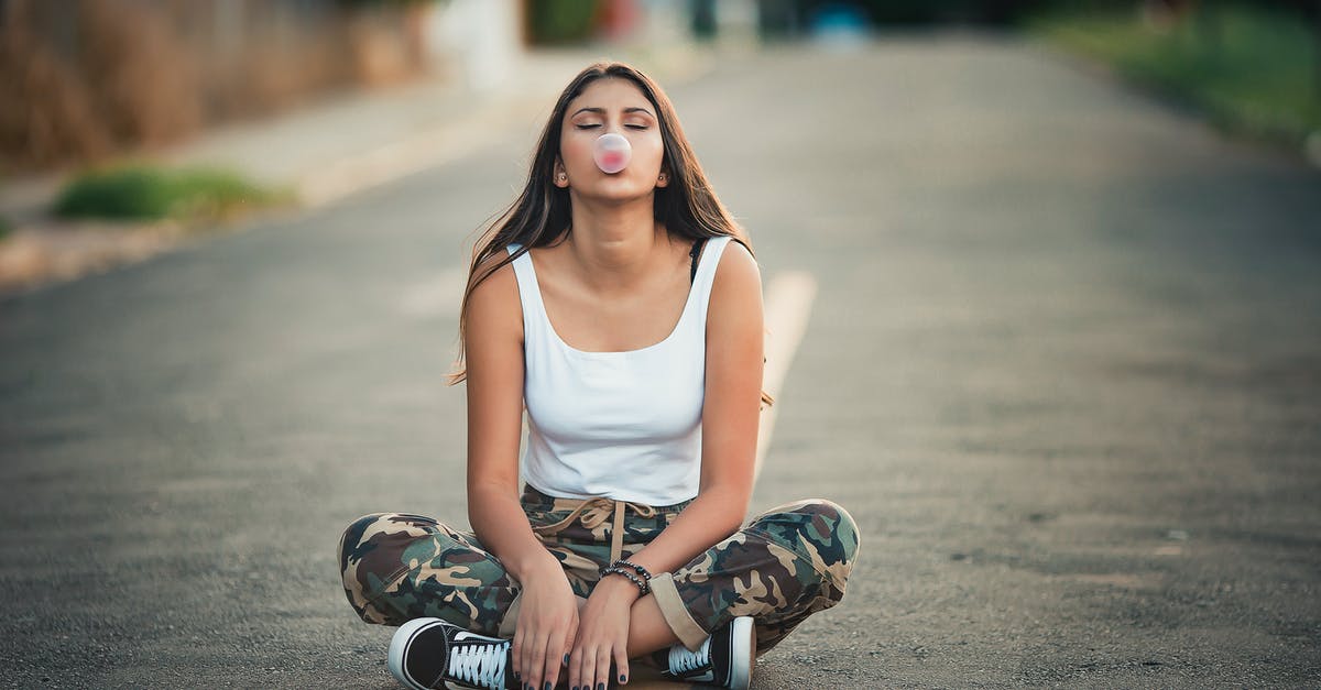 Why do Swiss road border crossings differ in setup? [closed] - Photo of Sitting in the Middle of the Road With Her Legs Crossed Blowing Bubble Gum