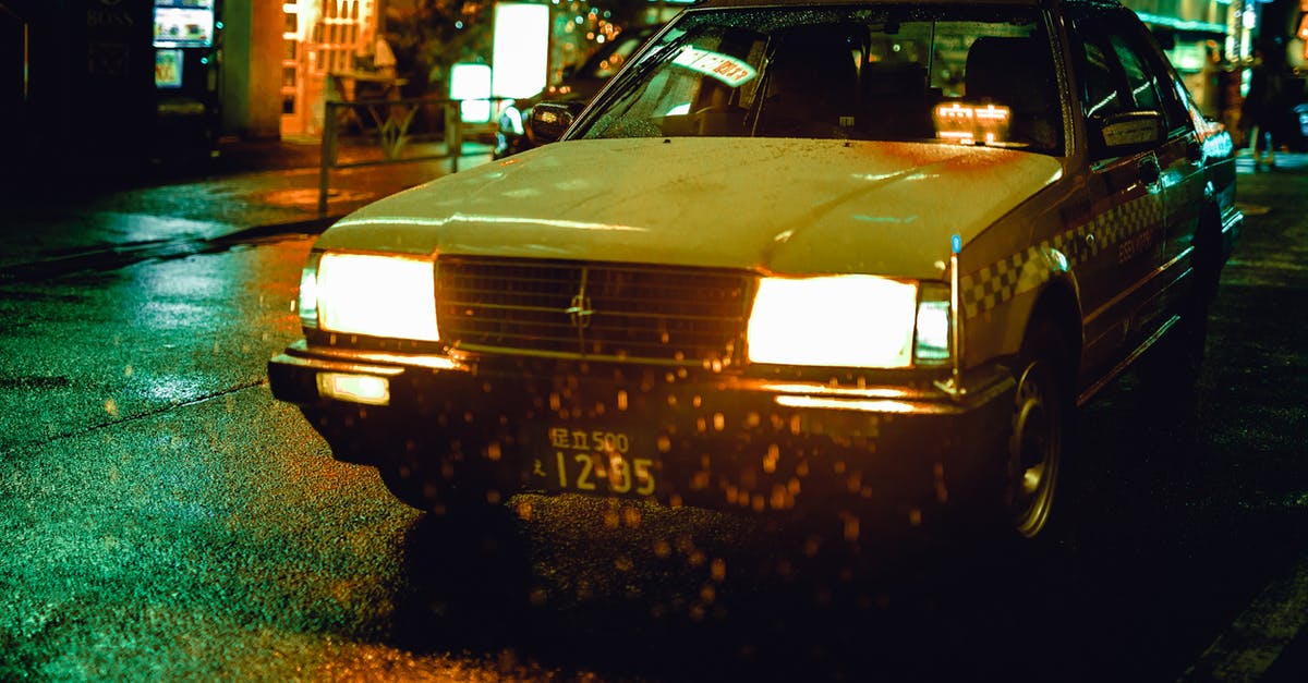 Why do taxis in Japan have mirrors on the hood? - White Sedan during Nighttime