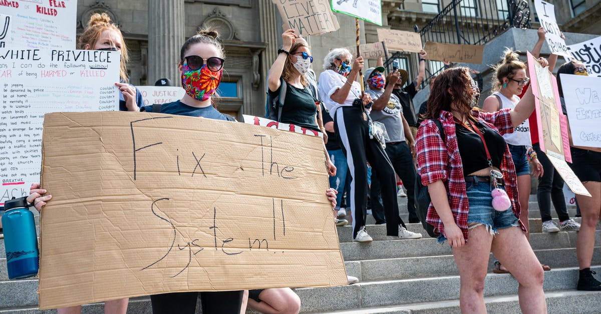 Why do UK people stand on the right on escalators? - Unrecognizable protesters with BLM placards in demonstration on staircase