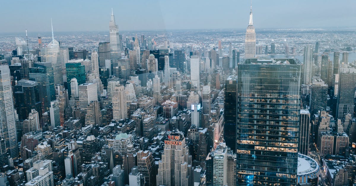 Why do US officers sometimes stamp non-US passports? [duplicate] - Drone view of modern high rise buildings and residential houses located on street of New York City against cloudless sky