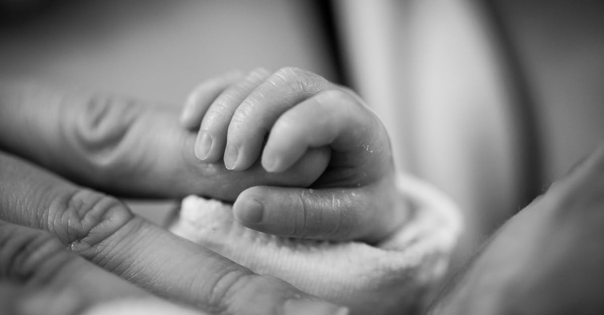 Why do visa applications require birth certificate? [closed] - Grayscale Photography of Baby Holding Finger