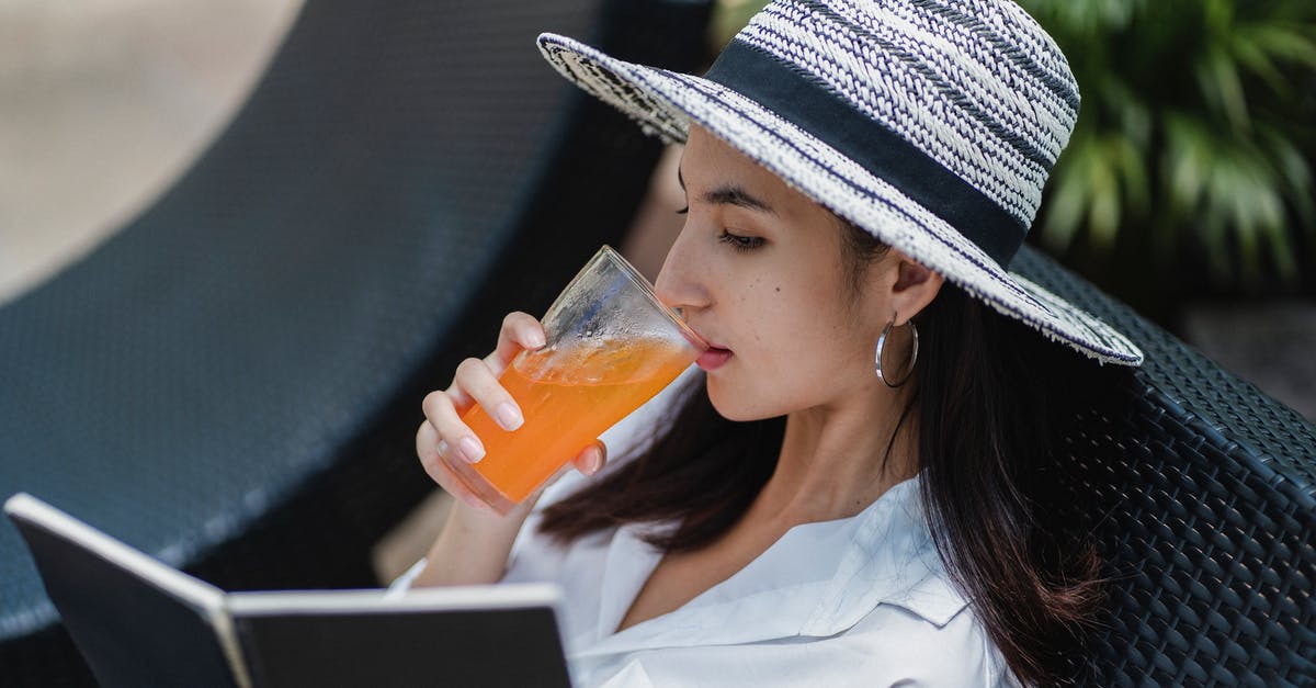 Why does my hotel booking price change over time? - Trendy young ethnic female relaxing on sunbed with glass of juice and reading book