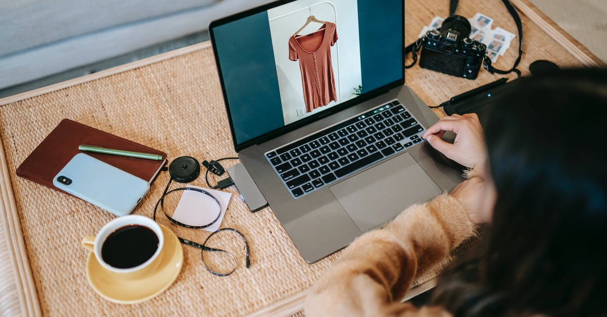 Why does my laptop charger not work with this adapter? - From above back view of crop anonymous female remote employee showing photography on netbook screen at table with hot drink