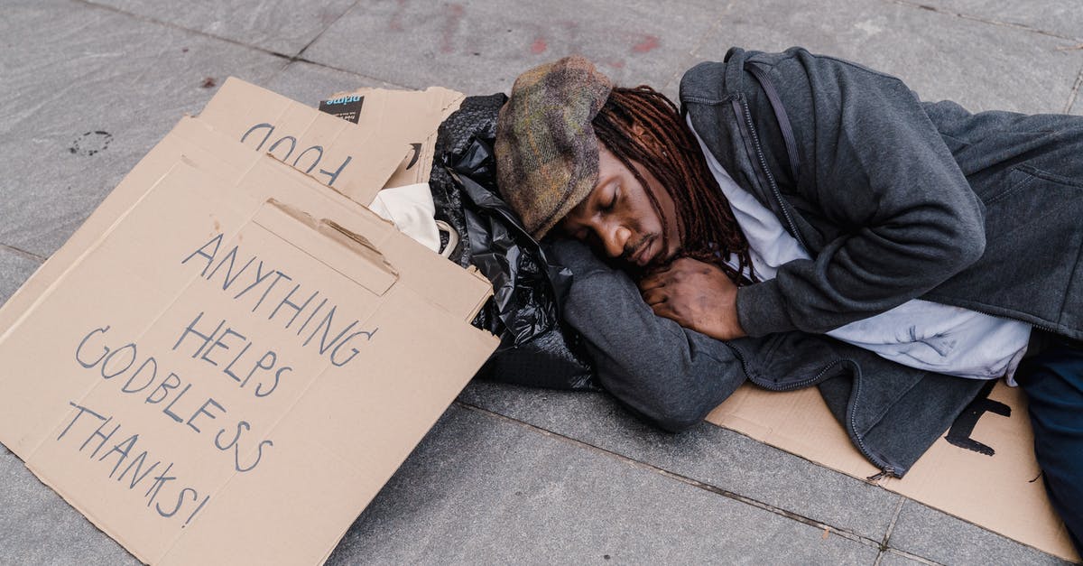 Why is homelessness not an issue in Tokyo? [closed] - Man in Gray Hoodie Lying on Gray Concrete Floor