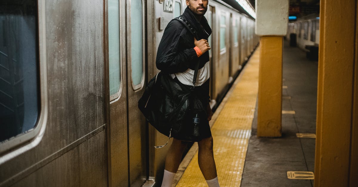 Why is the subway in Seoul so cheap? - Woman in Black Leather Jacket and Black Skirt Standing on Train Station