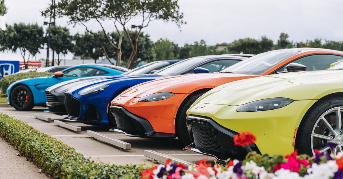 Why is there a line of parked cars at the left of the general lane in Otay Mesa Port of Entry? - Row of contemporary multicolored sports cars with strong engines parked on sunny street