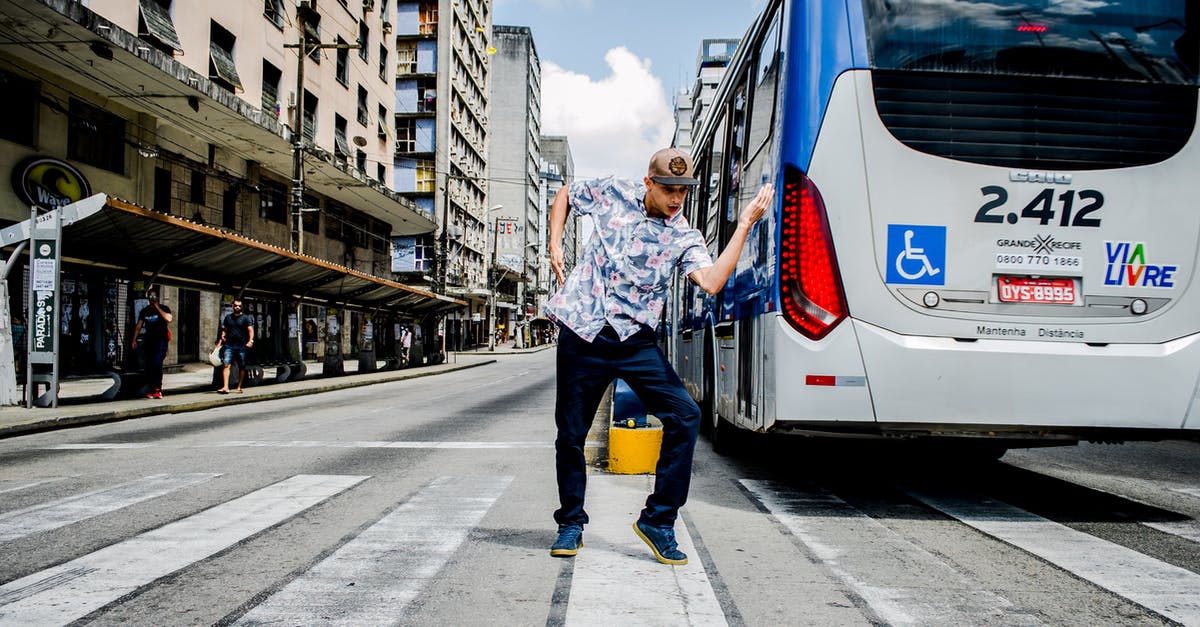 Why would TWO border checks be performed for the same bus upon entering Switzerland? - Man Dancing on Pedestrian Crossing Near Bus