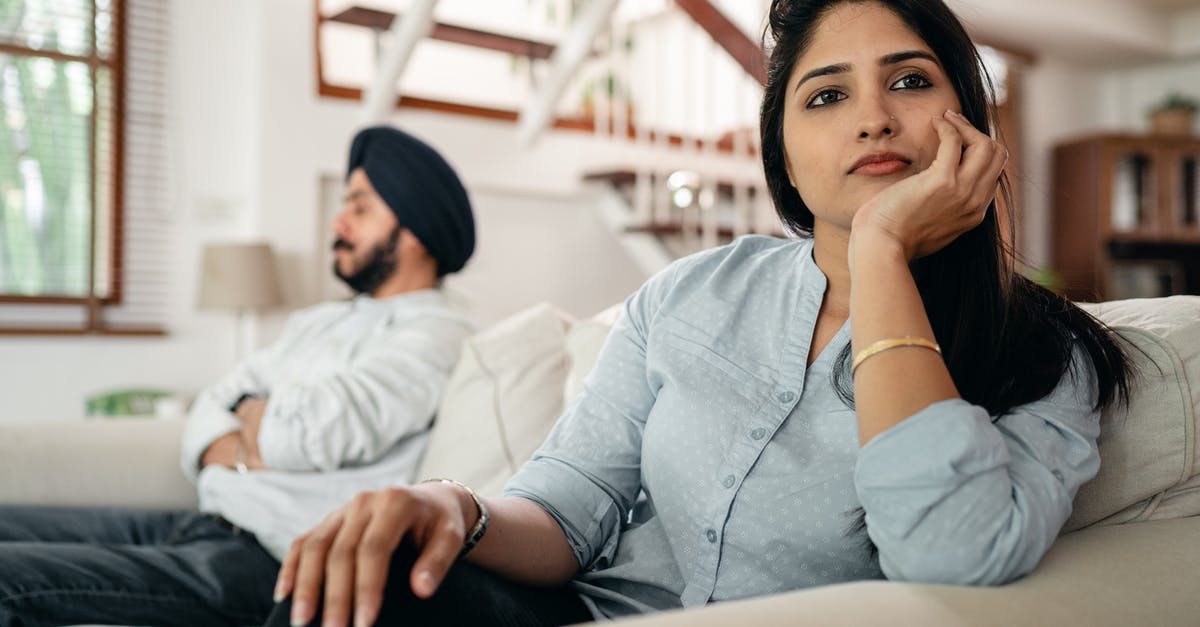 Will a Spanish visa issued to an Indian citizen with an incorrect date of birth cause me problems? - Sad young Indian woman avoiding talking to husband while sitting on sofa