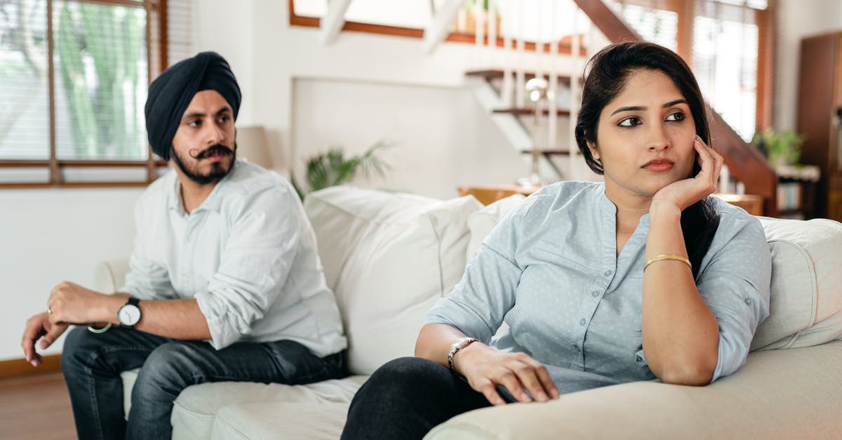 Will a Spanish visa issued to an Indian citizen with an incorrect date of birth cause me problems? - Upset young Indian couple having argument while sitting on couch
