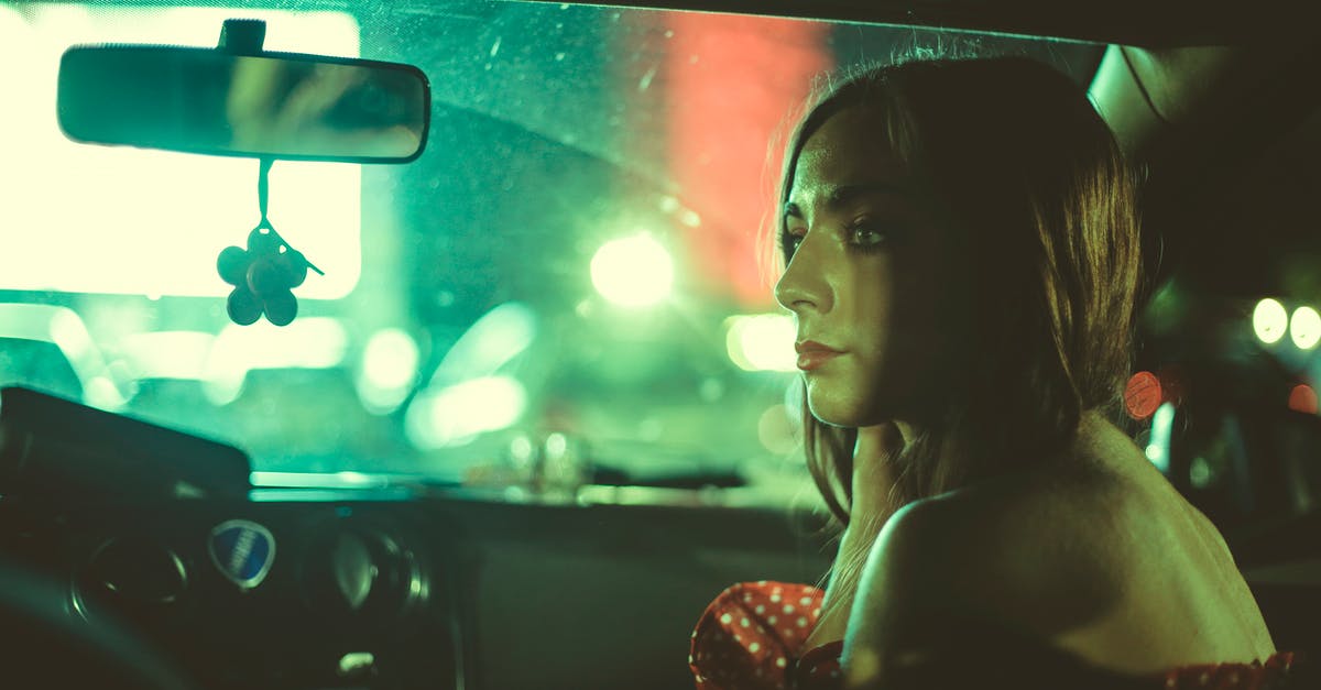 Will Eurostar have lots of rowdy passengers on a Saturday evening? - Side view of calm female with bare shoulders sitting in car on passenger seat near windshield with glowing light on blurred background