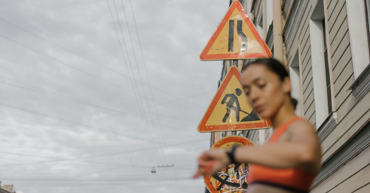 Will I fit or need an extension?(first time flyer) [duplicate] - A Woman in Orange Sports Bra Standing Near the Road Signs