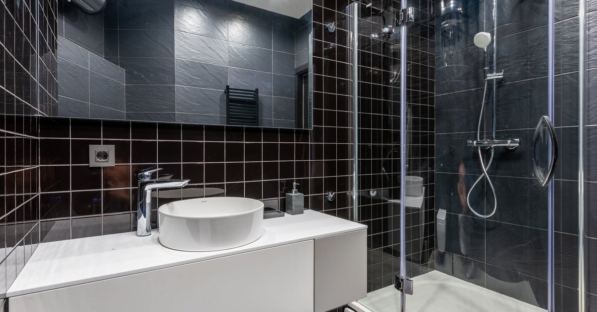 Will I need to clear US customs twice? [duplicate] - Interior of stylish modern bathroom with ceramic sink and shower unit with transparent glass doors and mirror