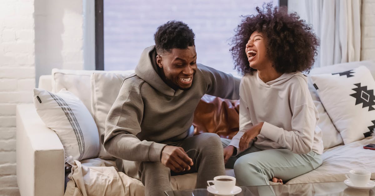 Will my boyfriend have any issues at UK border? [closed] - Cheerful young African American couple in casual outfit laughing happily while resting together on comfortable sofa at home